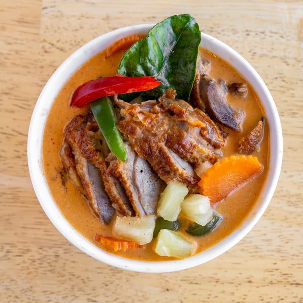 Delish Thai Kitchen's red curry with sliced duck, bell peppers, carrots, pineapple, and kaffir lime leaves.